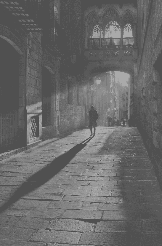persoon met lange schaduw staat in steeg
